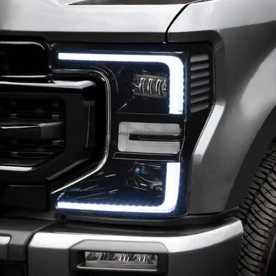 Close-up of a Ford Superduty headlight with white DRLs.